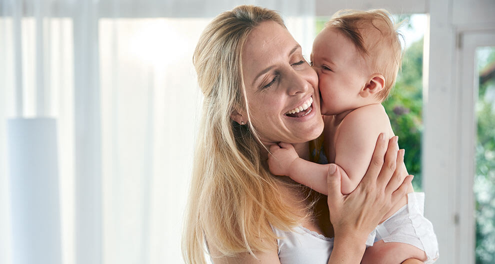 A woman is holding a baby.