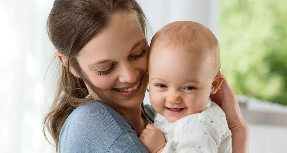 A woman lovingly holds a baby.